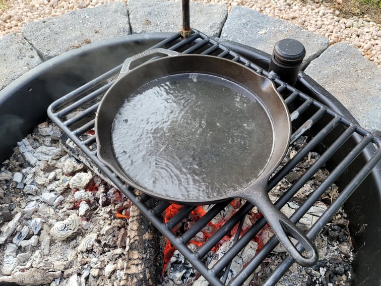 Boiling water in a dirty cast iron skillet to clean it 