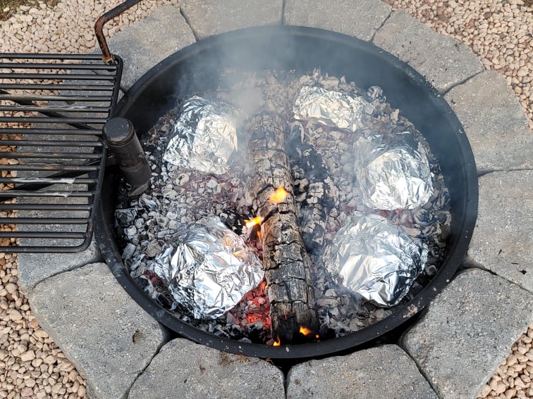 foil packet dinners cooking in a fire pit 