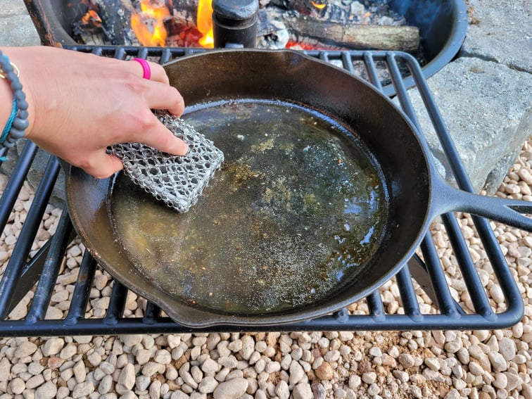 Cleaning a cast iron skillet with a chain mail scrubber 