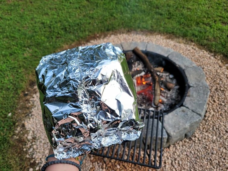 a prepared foil packet dinner ready to be cooked in the campfire 