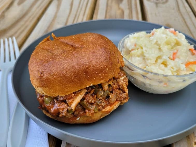 Campfire Sloppy Joes on a bun with a side of coleslaw