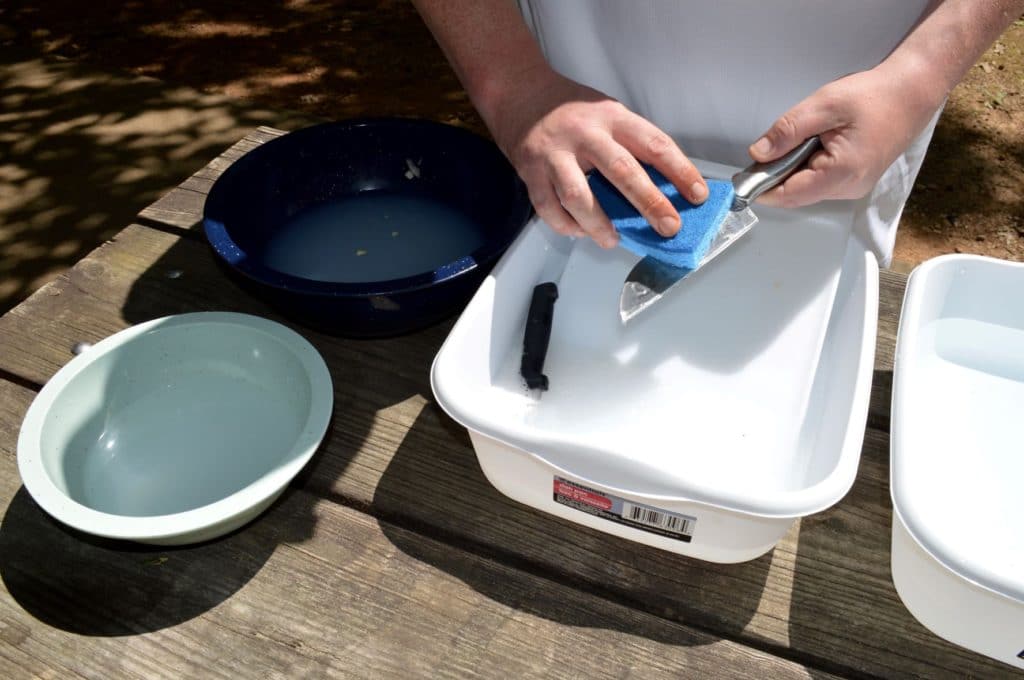 washing dishes while camping in plastic dishpans