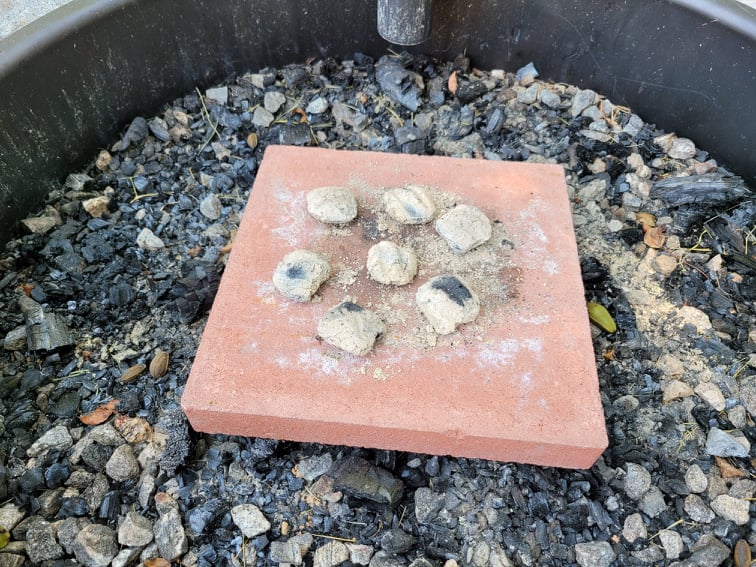 charcoal briquettes on a concrete block in a fire pit