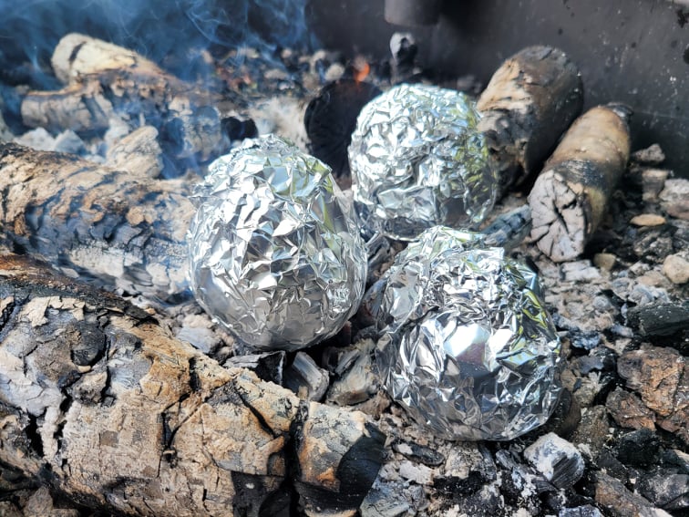 orange peel muffins cooking in campfire embers 