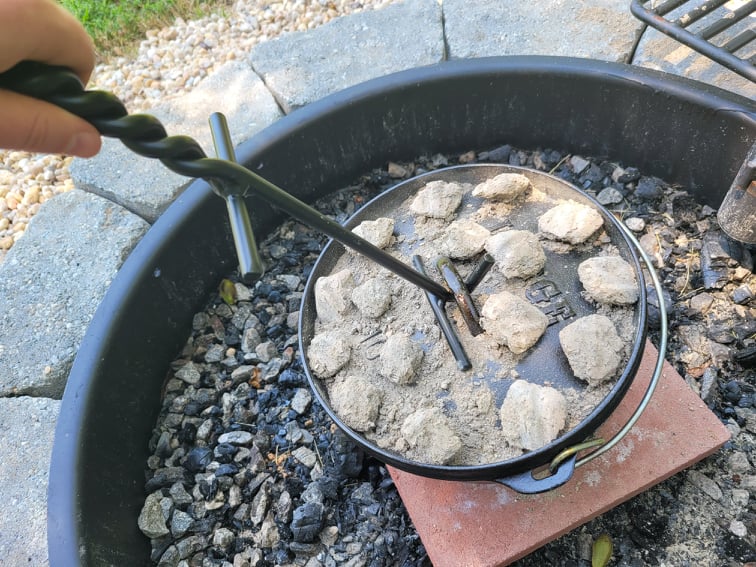 Removing hot dutch oven lid with a lid lifter tool