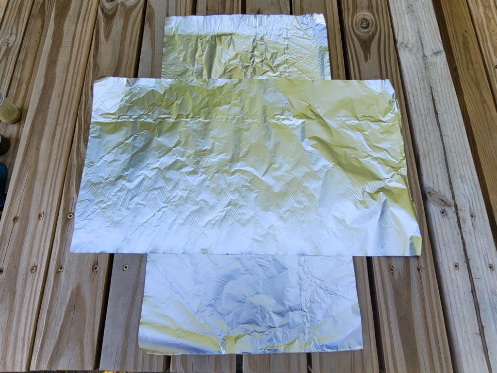 two sheets of aluminum foil on a picnic table 