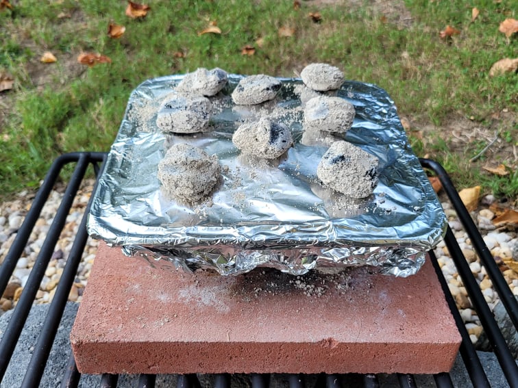 cooking a foil packet meal with charcoal