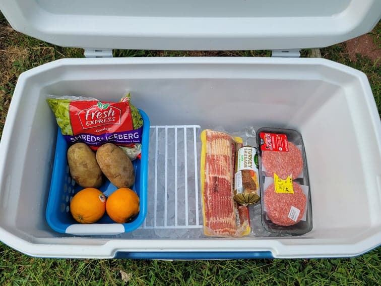 cooler with ice, meat, and a produce bin 