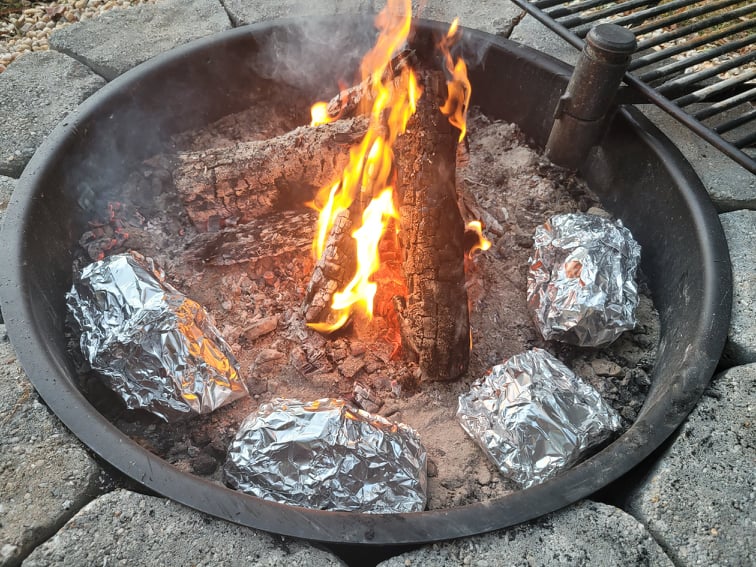 Cooking camping foil packet meals in a fire pit