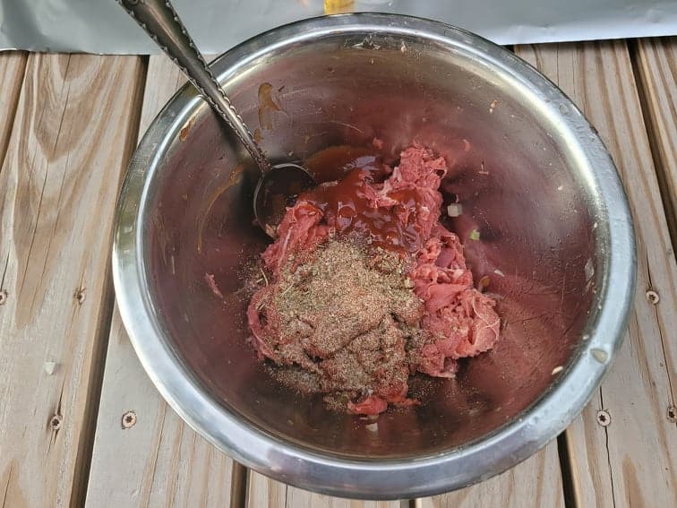 shaved beef, spices, and a sauce mixture in a bowl