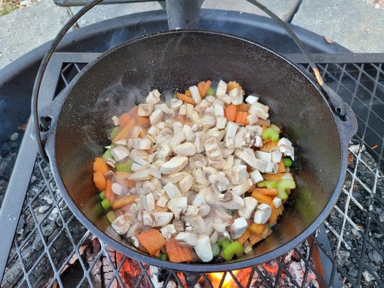mushrooms, garlic, and stew veggies cooking in the dutch oven