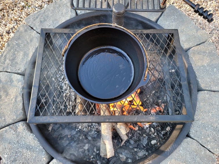 heating cooking oil in a dutch oven over the campfire