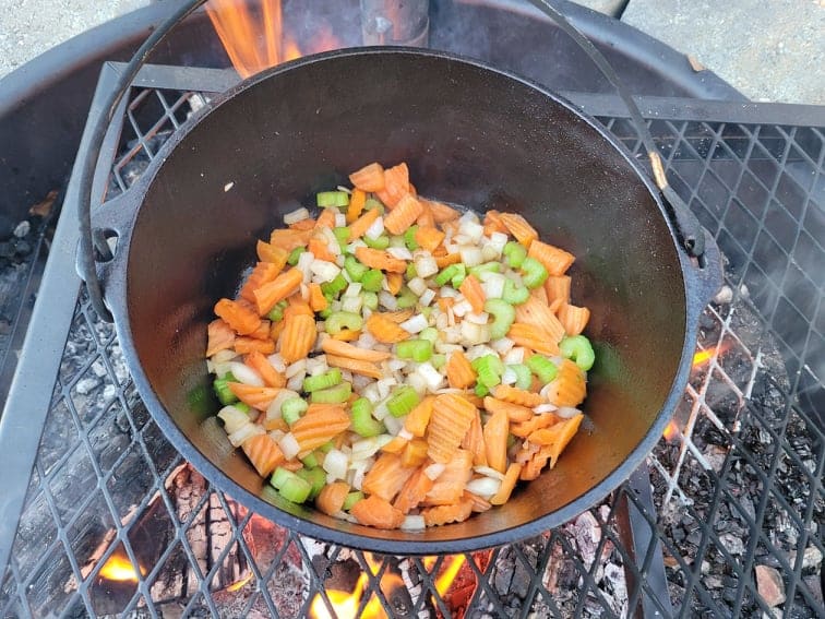 onions, carrots, and celery cooking in the dutch oven