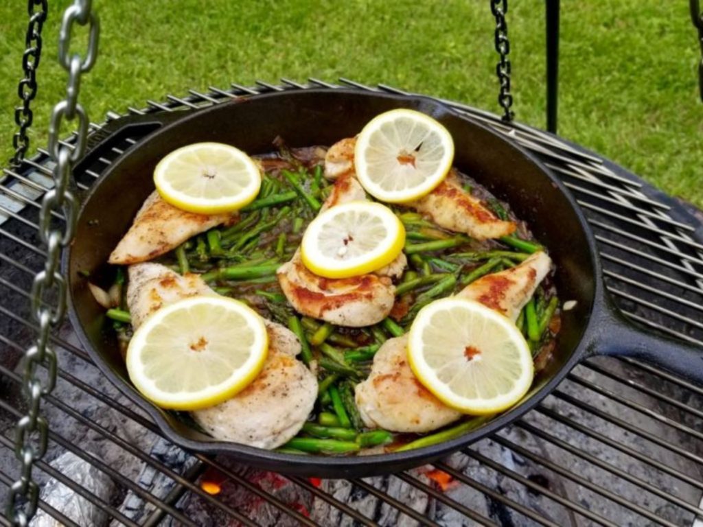 cooking lemon chicken and asparagus in a cast iron skillet 