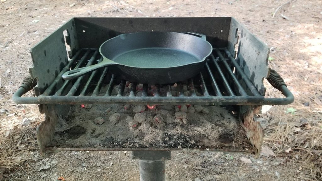 cast iron skillet on a camping grill