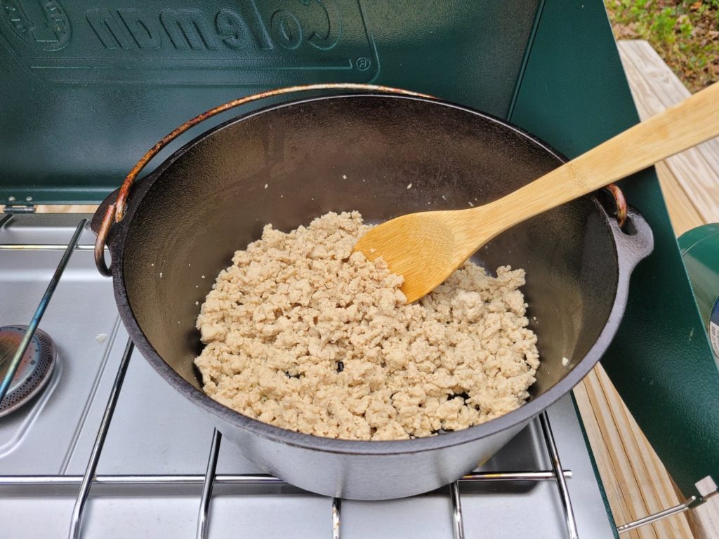 browning ground meat in a dutch oven on the camping stove