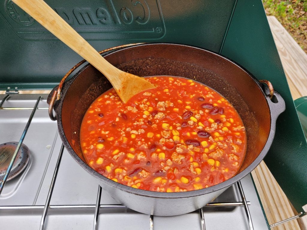 taco soup simmering in a dutch oven on a camping stove