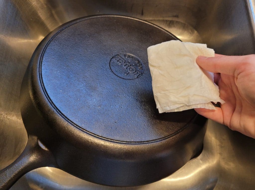 A clean paper towel without any soot residue after washing and drying a cast iron skillet