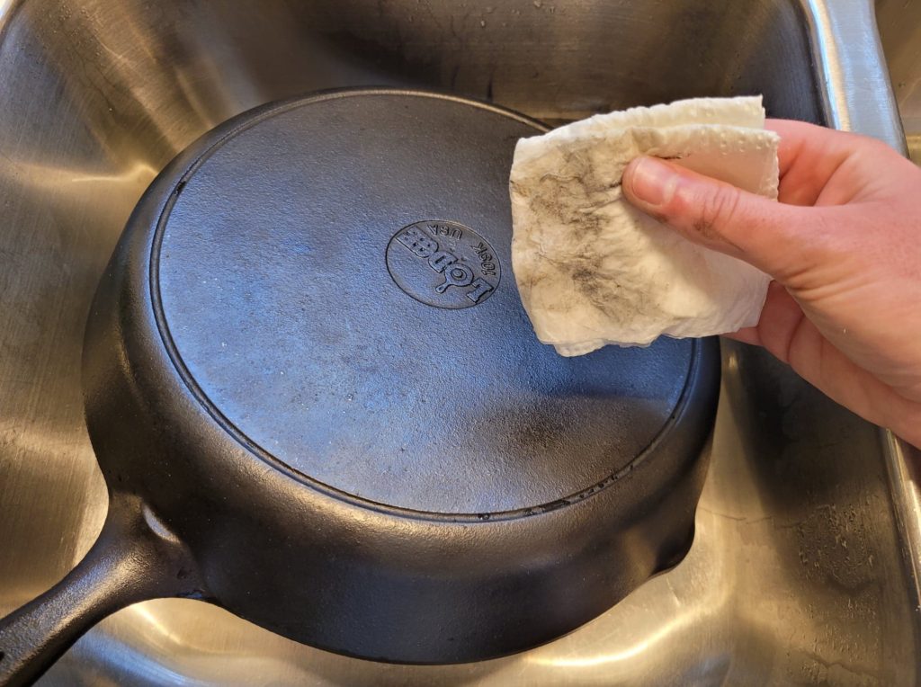 Soot residue on a paper towel after washing cast iron skillet with soap