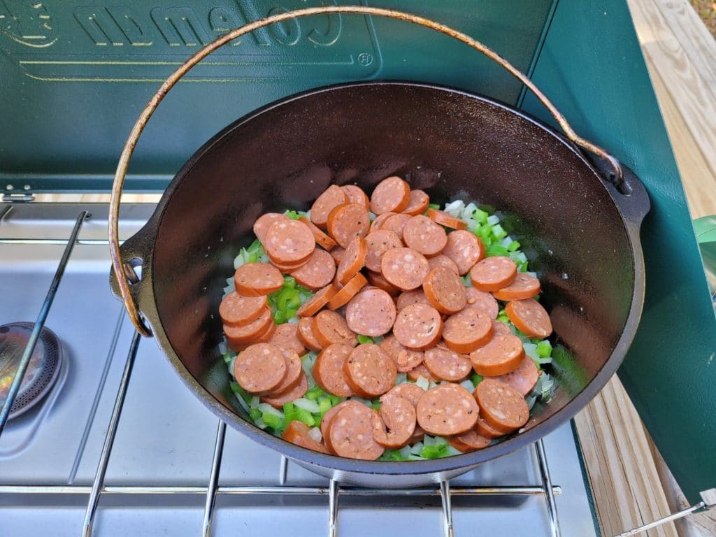peppers, onions, and sliced cajun sausage in a dutch oven. 