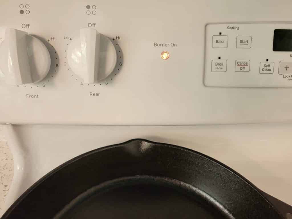 cast iron pan preheating on a stovetop burner 