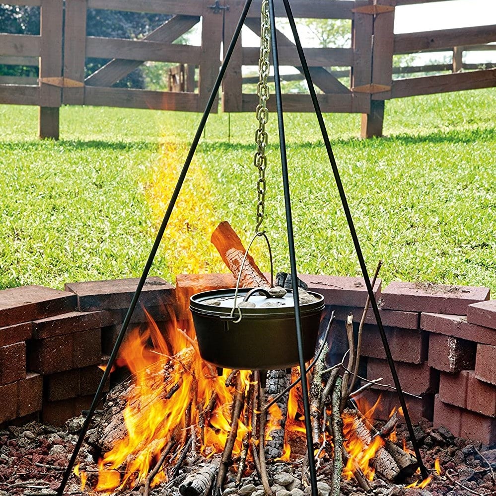 dutch oven hanging from a camping tripod over the fire pit