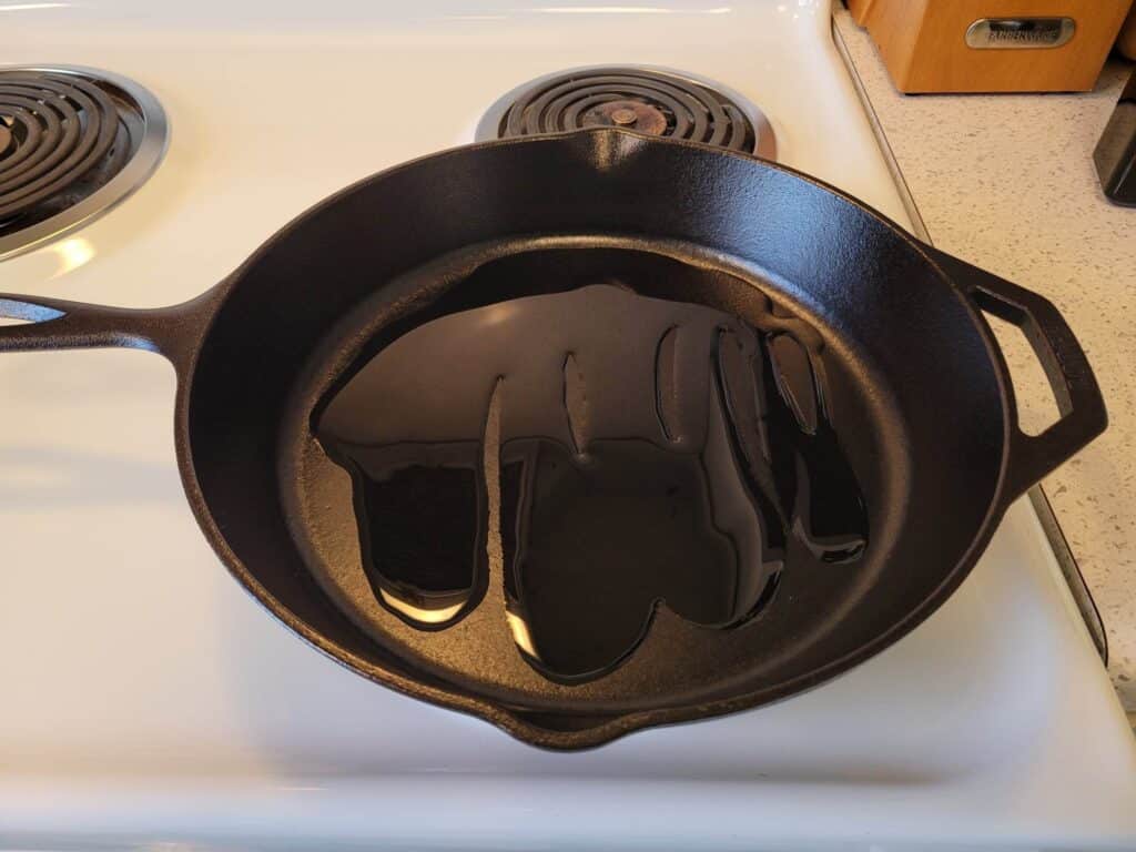 heating cooking oil in a cast iron skillet on the stovetop