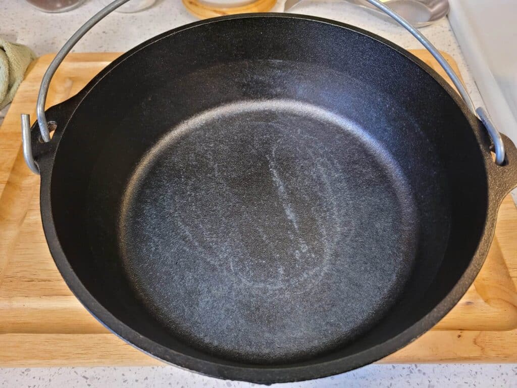Dutch oven after boiling water with partially removed seasoning.