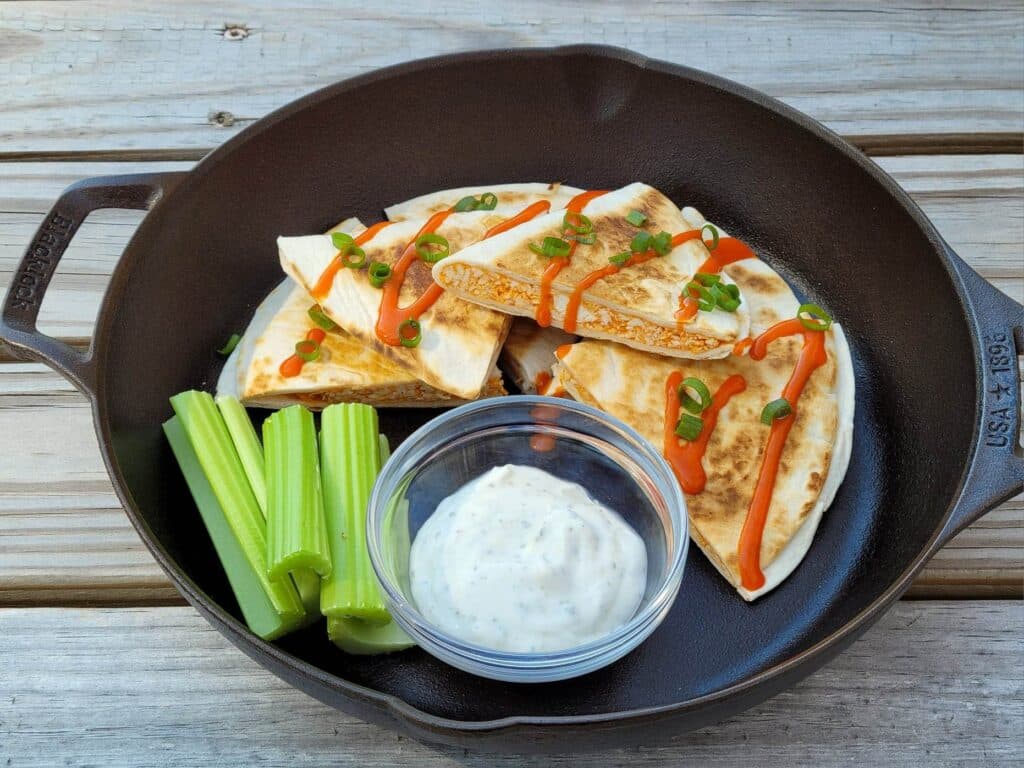Buffalo Chicken Quesadillas in cast iron skillet served with ranch dip and celery sticks