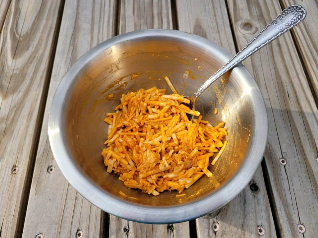 shredded chicken, buffalo sauce, and cheese mixed together in a bowl