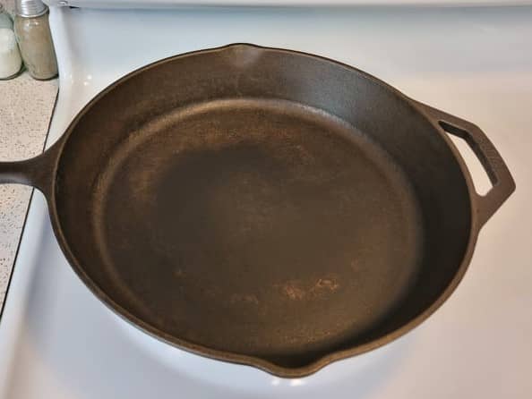 cast iron skillet surface appearing dry and unevenly colored prior to oiling after use
